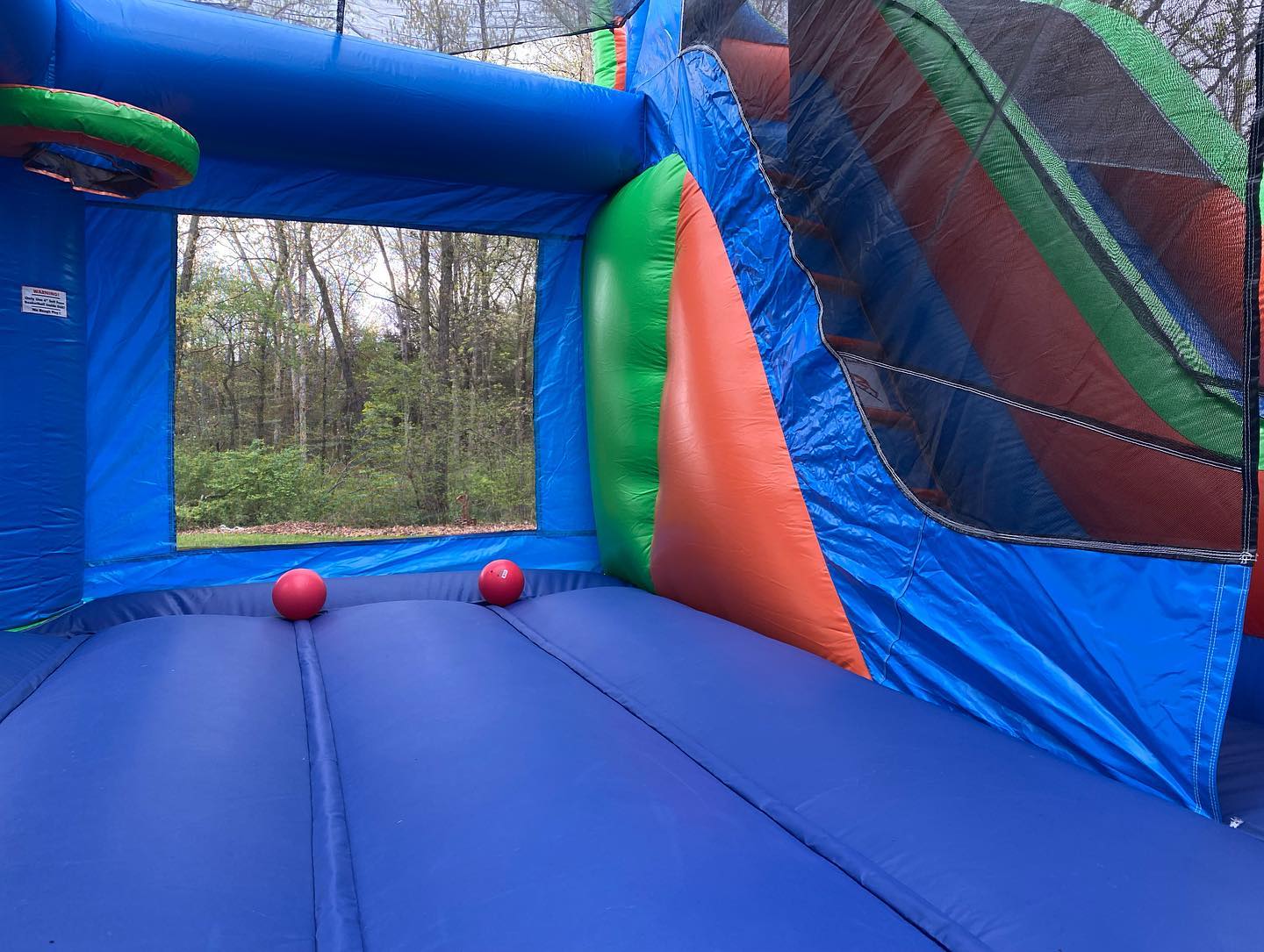 Inside view of the Balloon Combo bounce house showing the spacious bounce area and basketball hoop