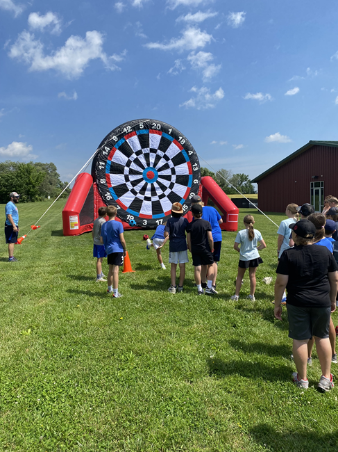 Guests playing Soccer Darts inflatable game at a Backyard Party Rentals event