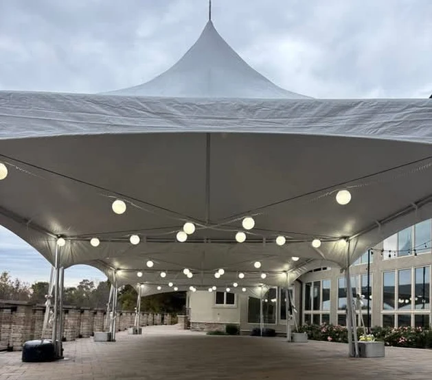 20x40 tent with string lights at an evening outdoor event by Backyard Party Rentals