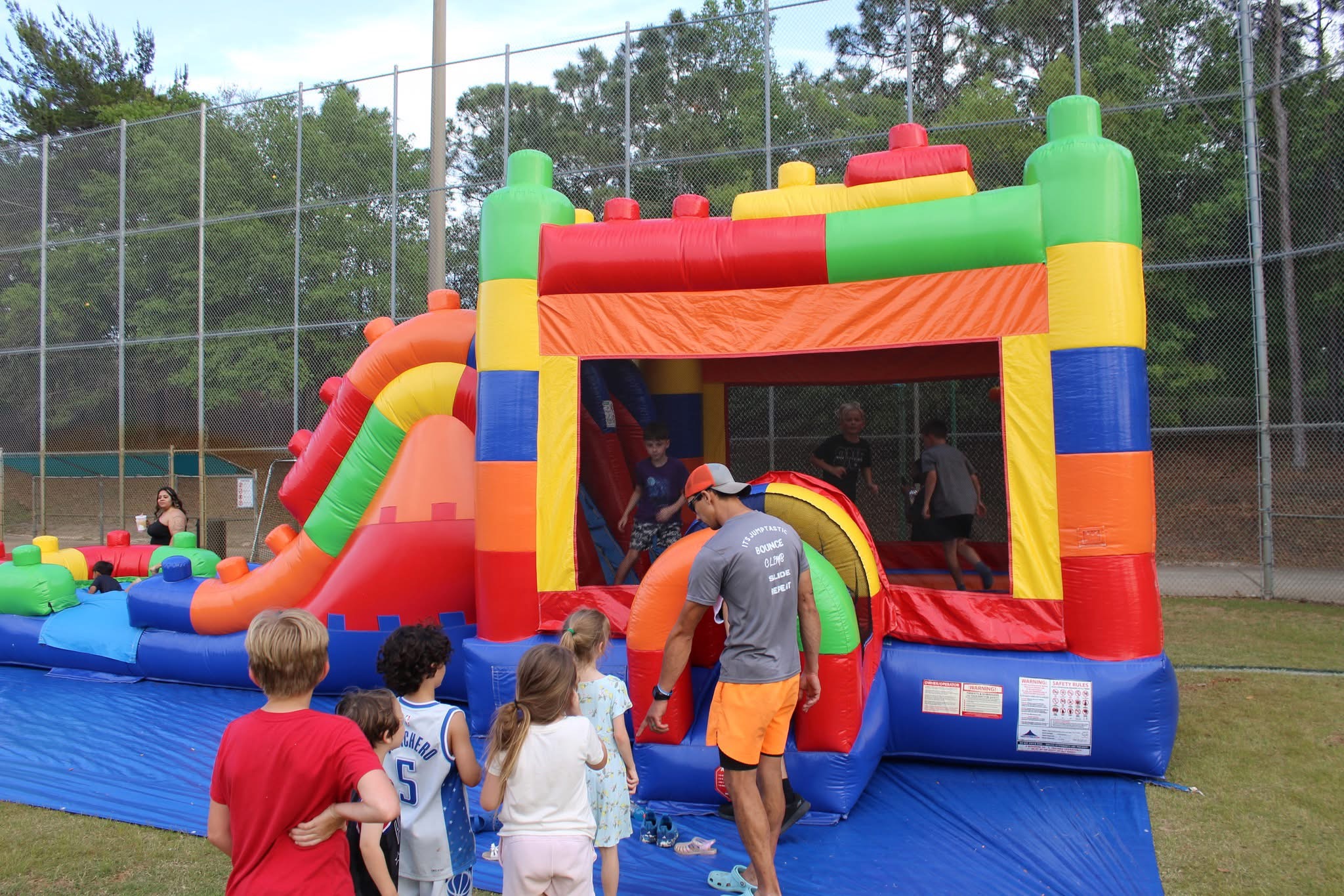 Colorful inflatable bounce house and slide combo at a military family day event