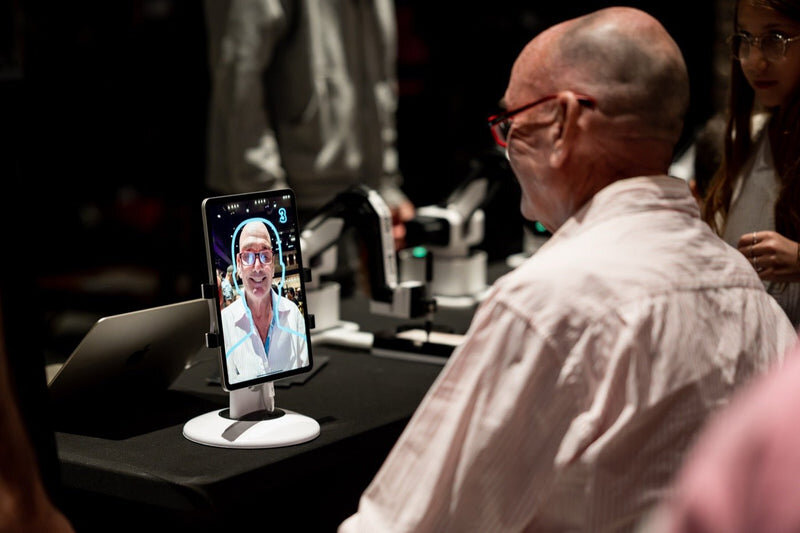 Guest watching the robot arm draw his portrait at an evening gala
