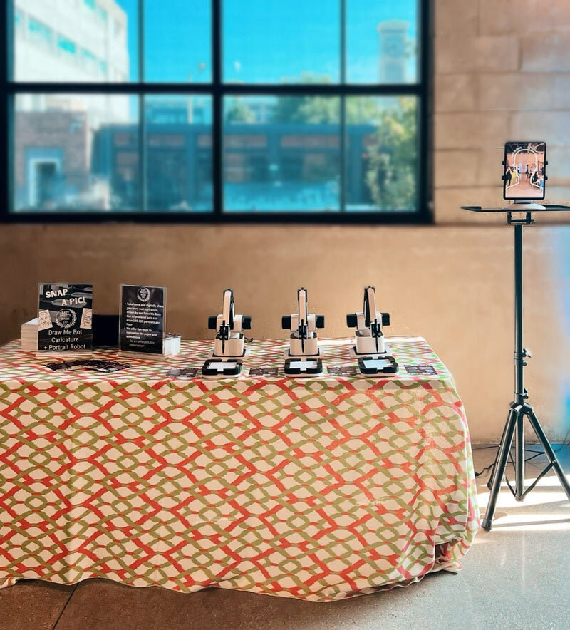 AI robot caricature artist table setup at an indoor event