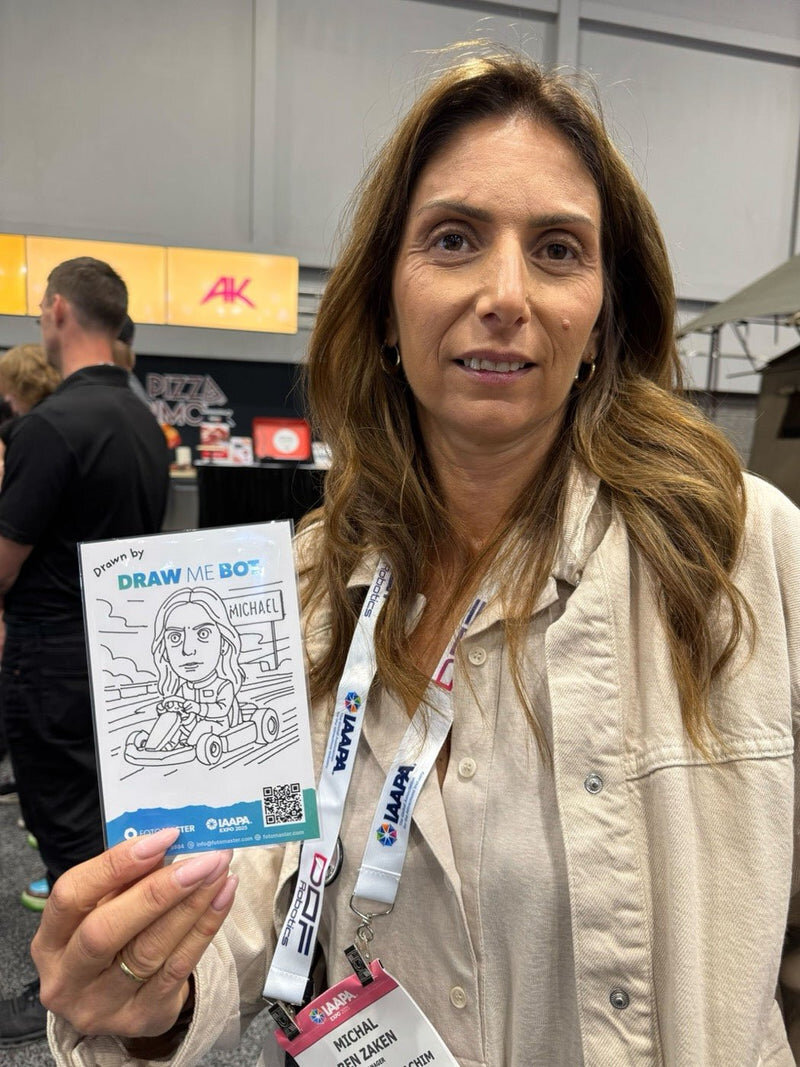 Trade show attendee holding a caricature drawn by the robot