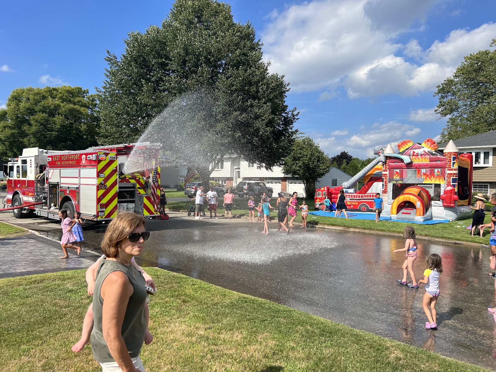 Kids enjoying inflatable water slide at outdoor summer party